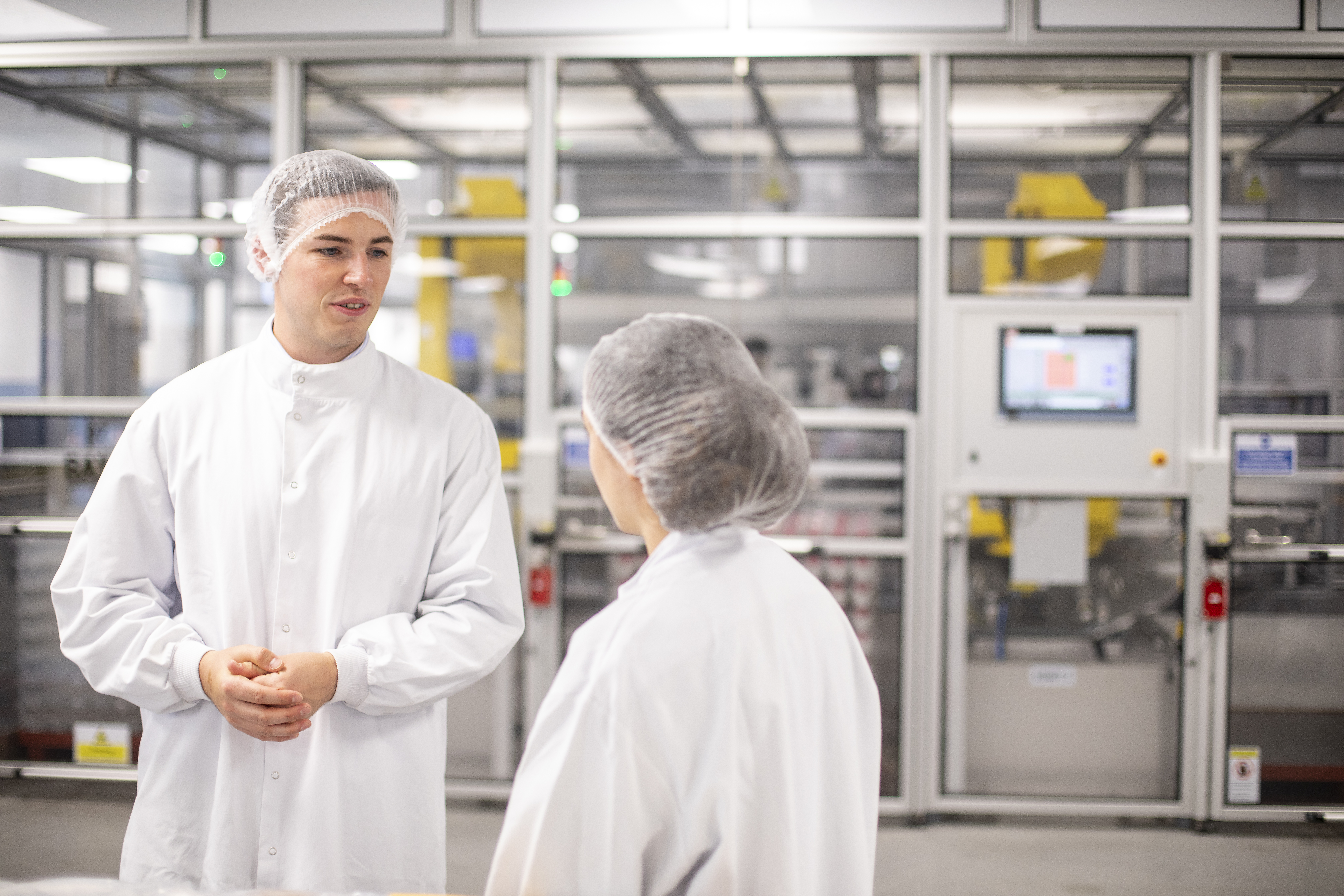 Deux employés discutant ensemble dans un bâtiment de production