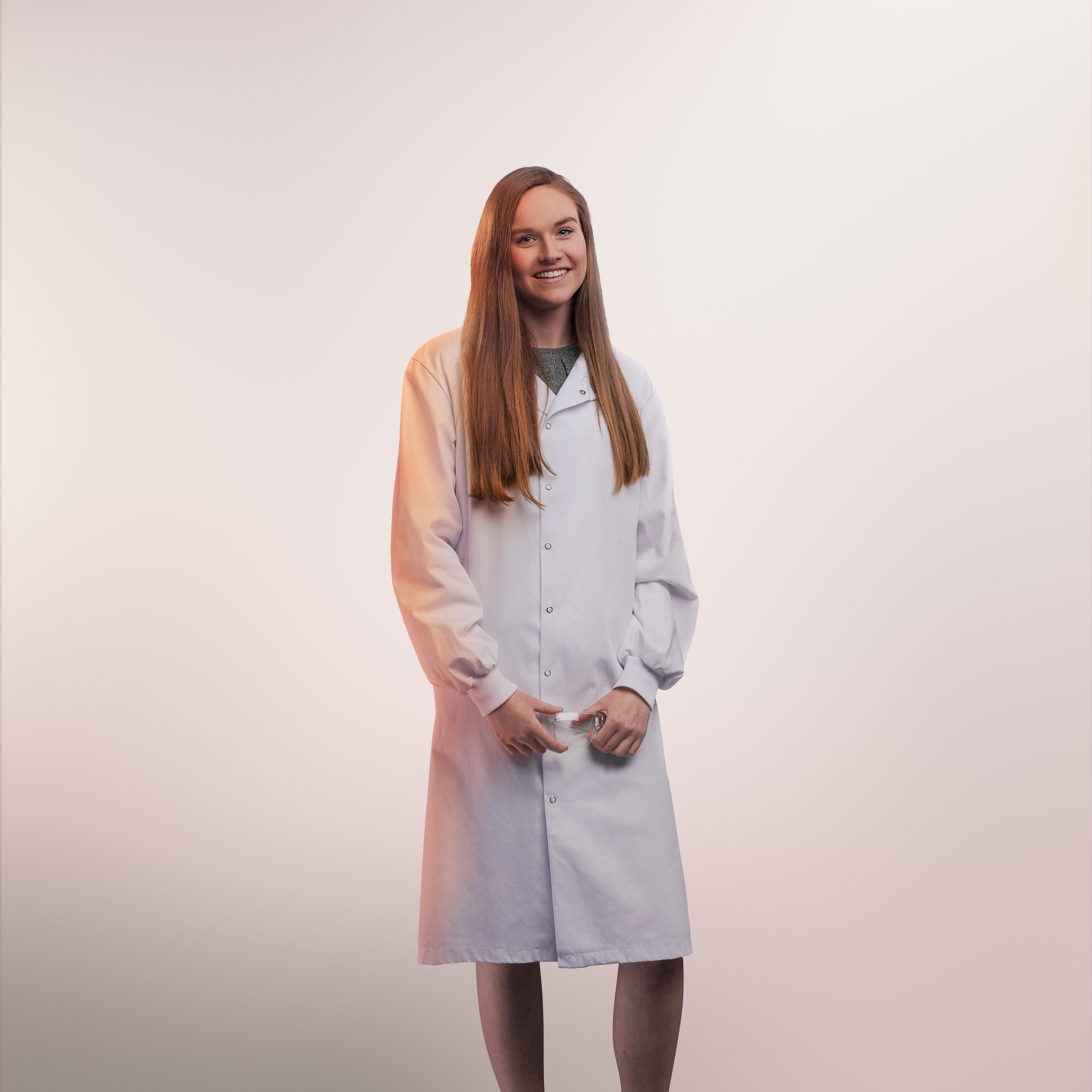 Portrait en studio avec fond clair d'une employée en blouse blanche