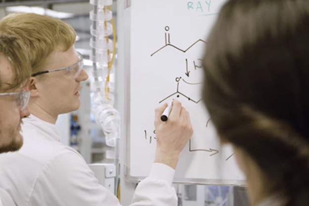 Employés travaillant sur un tableau blanc et dessinant des molécules