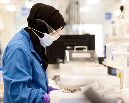 Employée travaillant dans un laboratoire avec des gants et un masque
