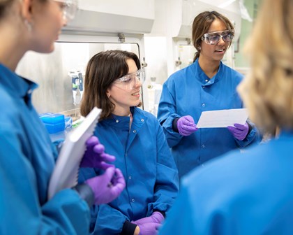 Quatre employées discutant ensemble dans un laboratoire