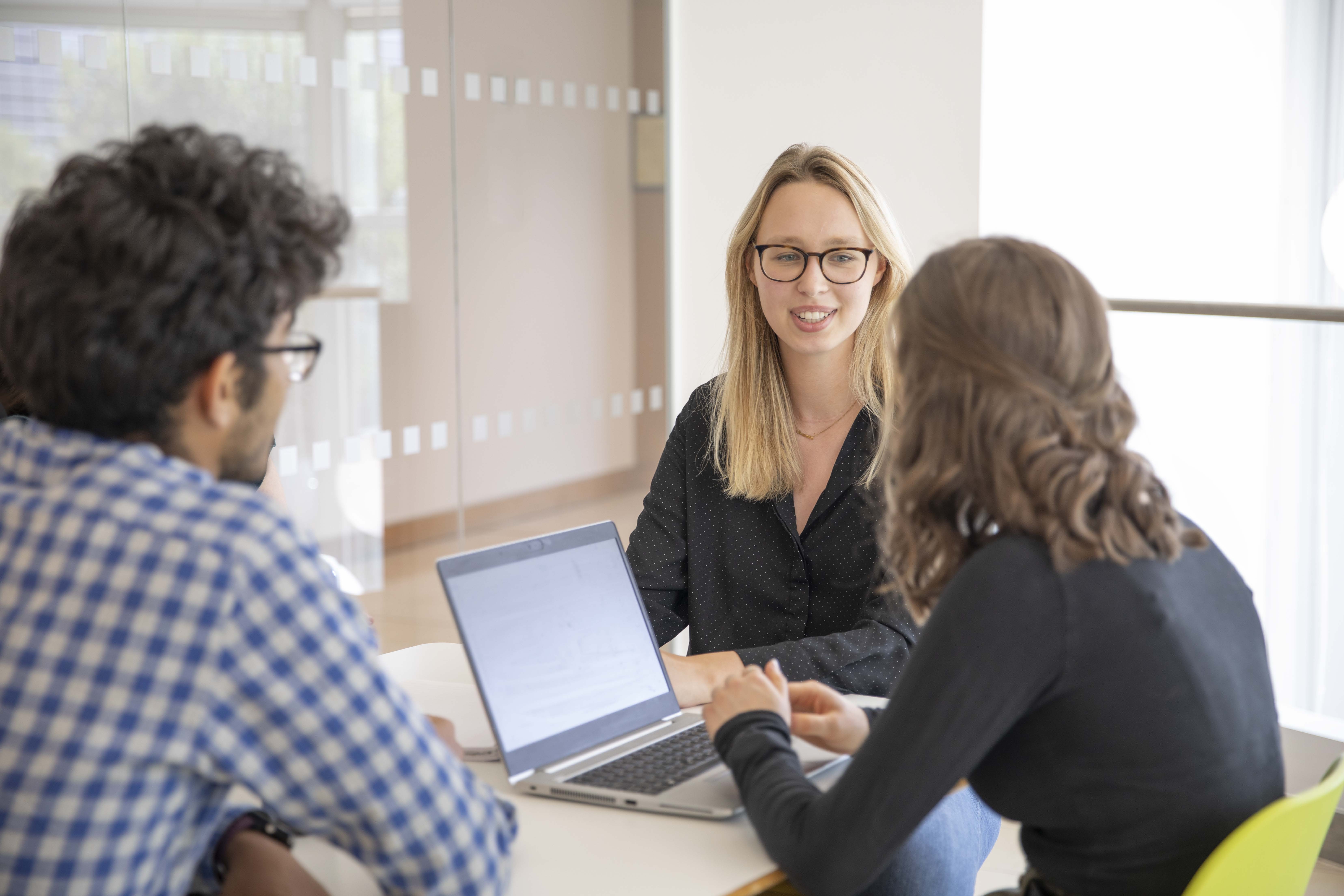 Trois employés à une table discutant ensemble