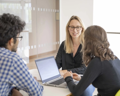 Trois employés à une table discutant ensemble