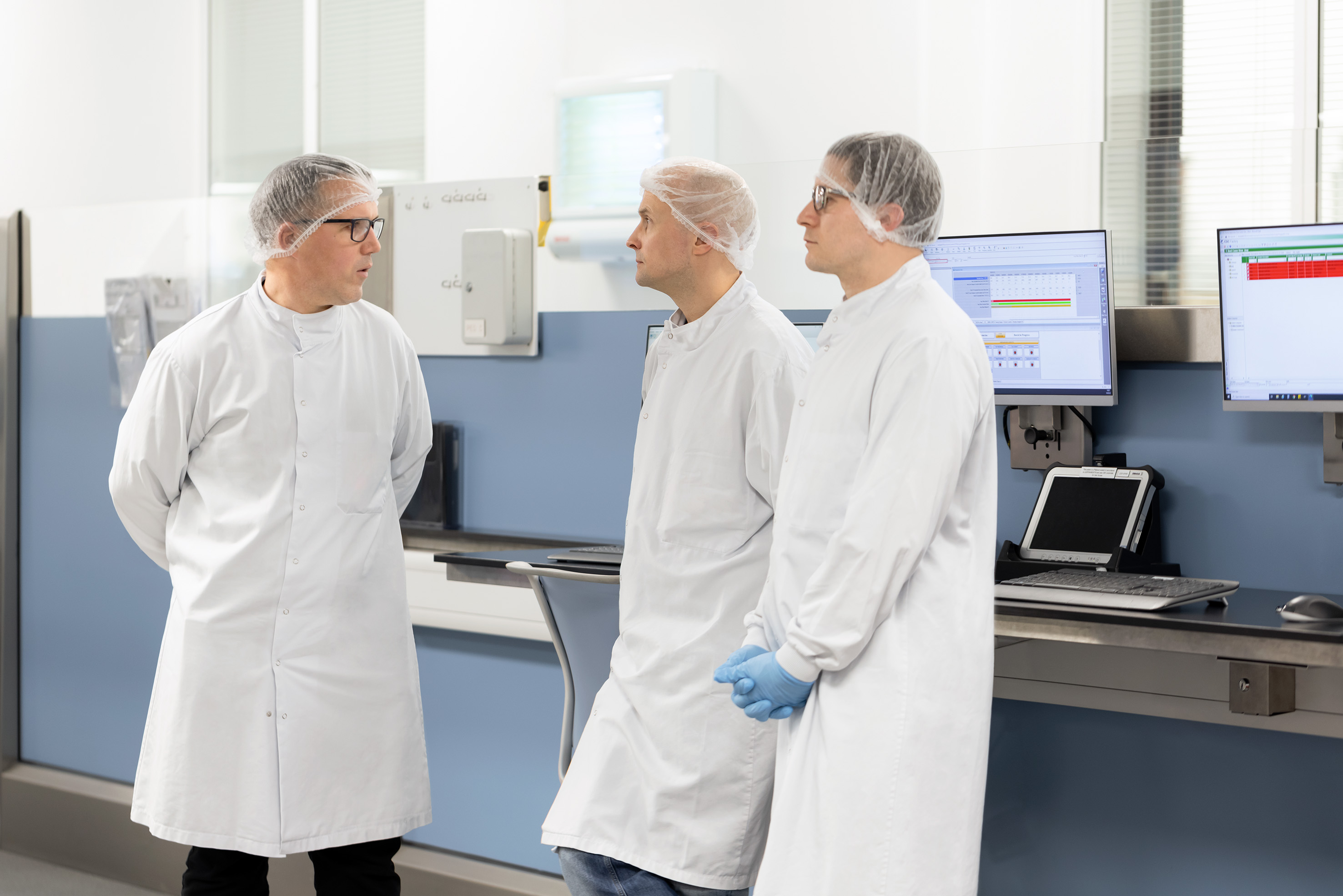 Trois employés qui se réunissent dans le département production