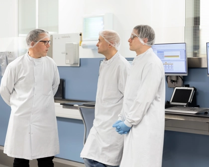 Trois employés qui se réunissent dans le département production