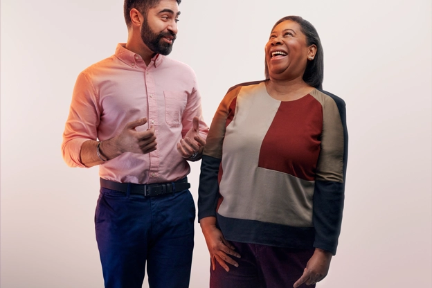 Deux employés prennent la pose pour une photo et rient ensemble