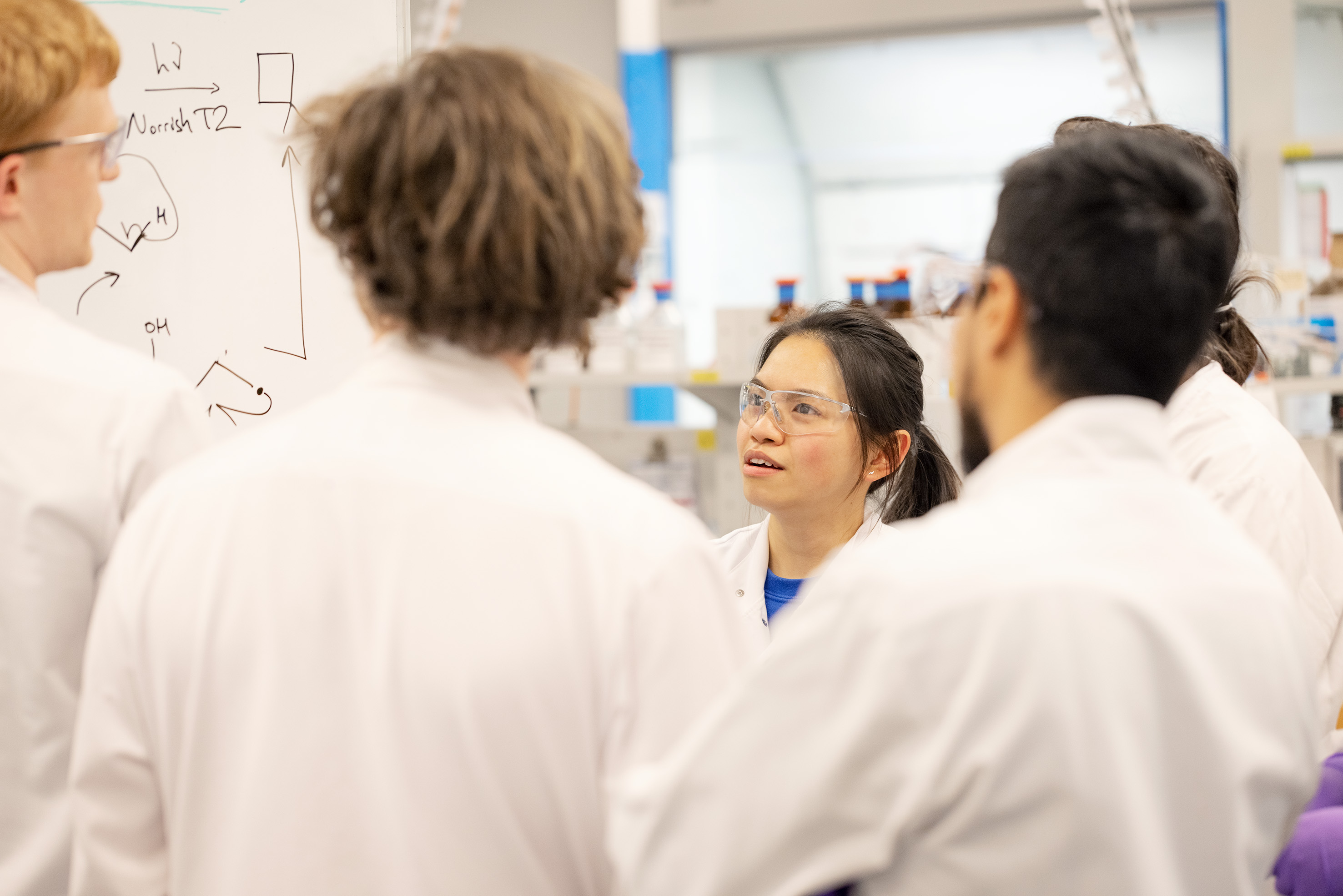 Scientifiques en conversation devant un tableau blanc