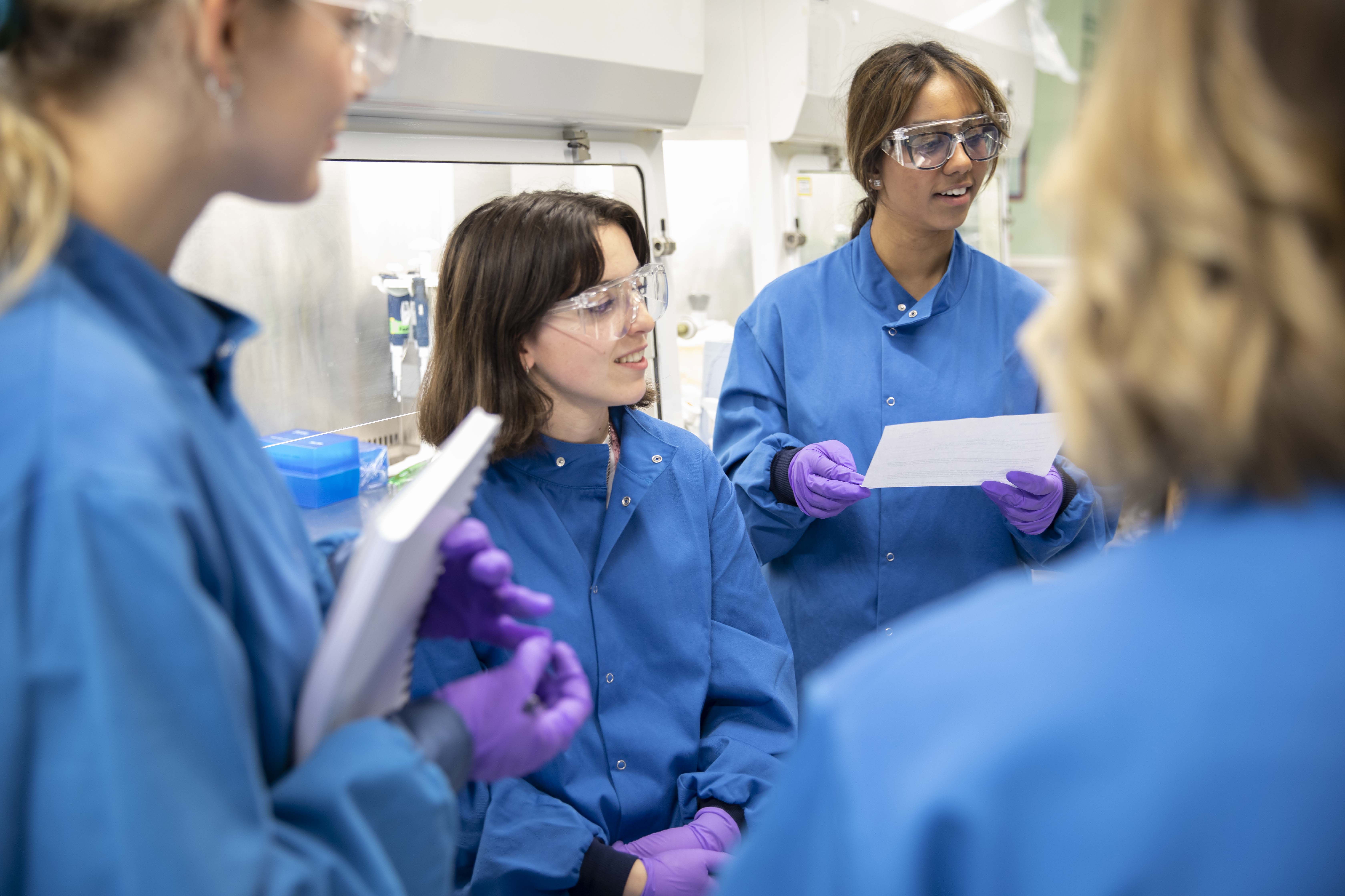 Quatre employées discutant ensemble dans un laboratoire