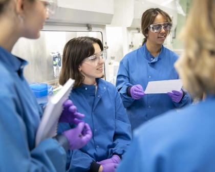 Quatre employées discutant ensemble dans un laboratoire