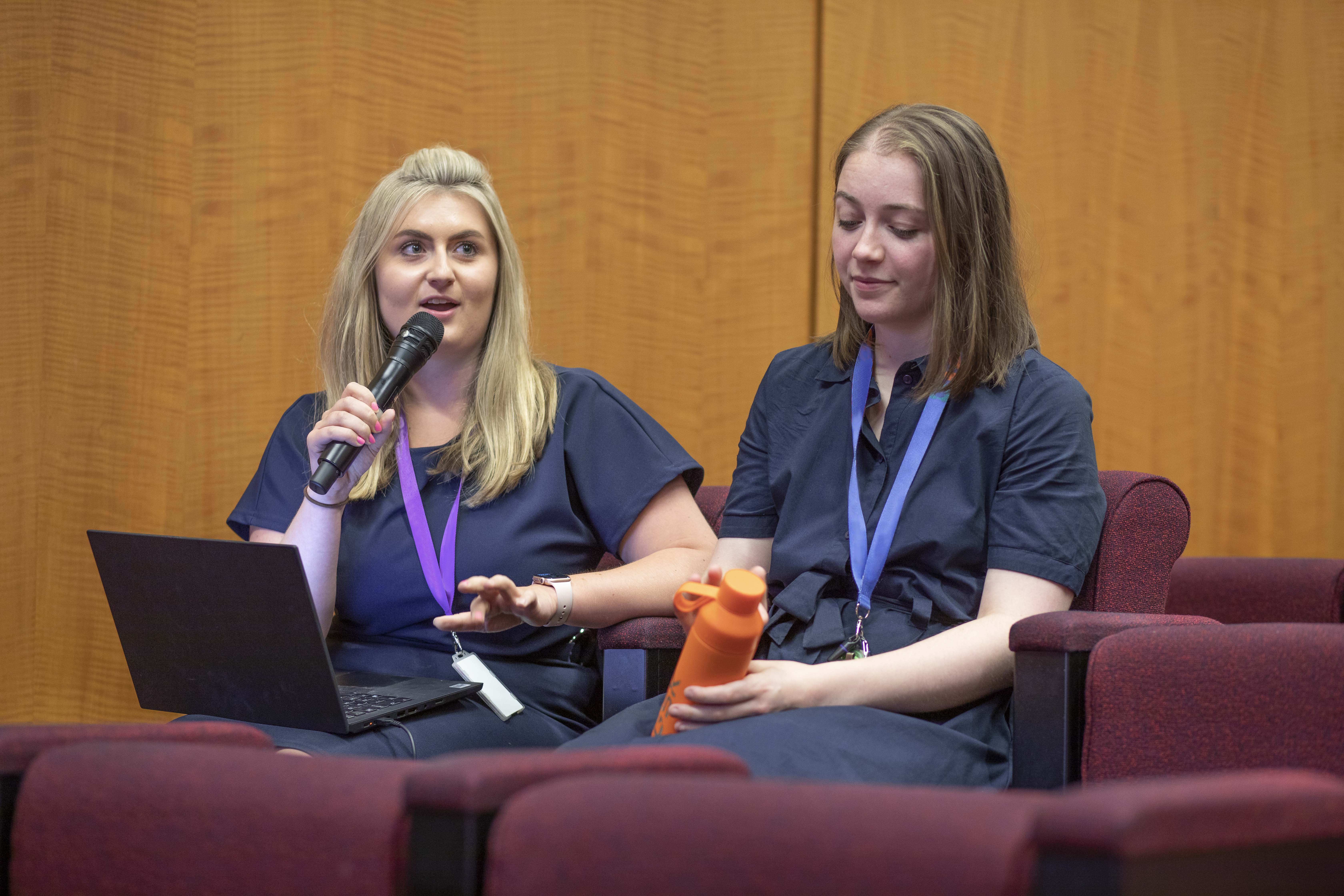 Deux employés en pleine prise de parole durant une conférence