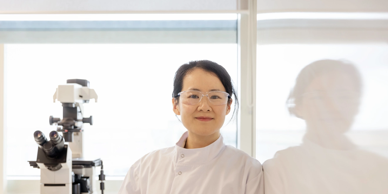 Femme scientifique dans un laboratoire avec lunettes et microscope