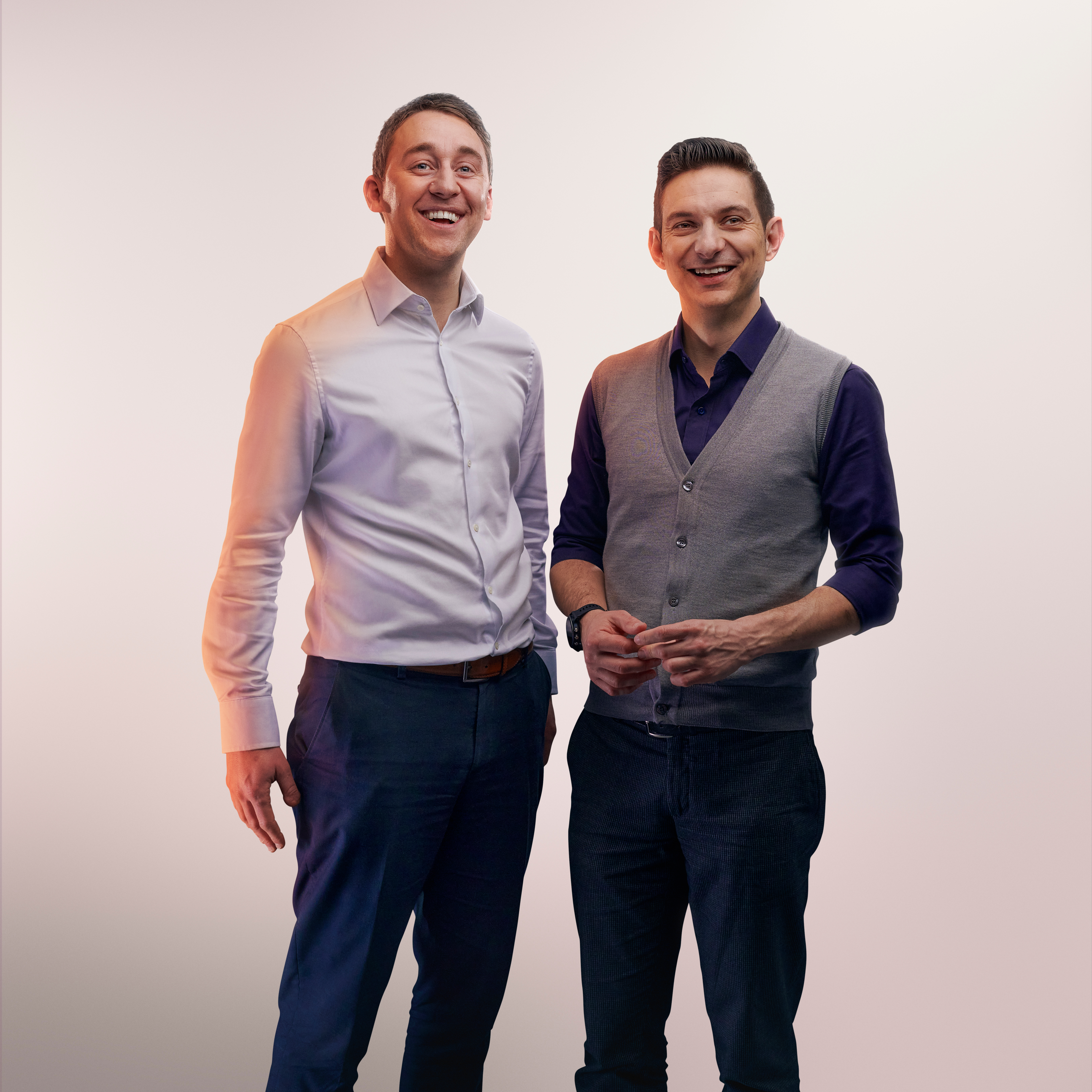 Portrait en studio avec fond clair de deux employés souriants