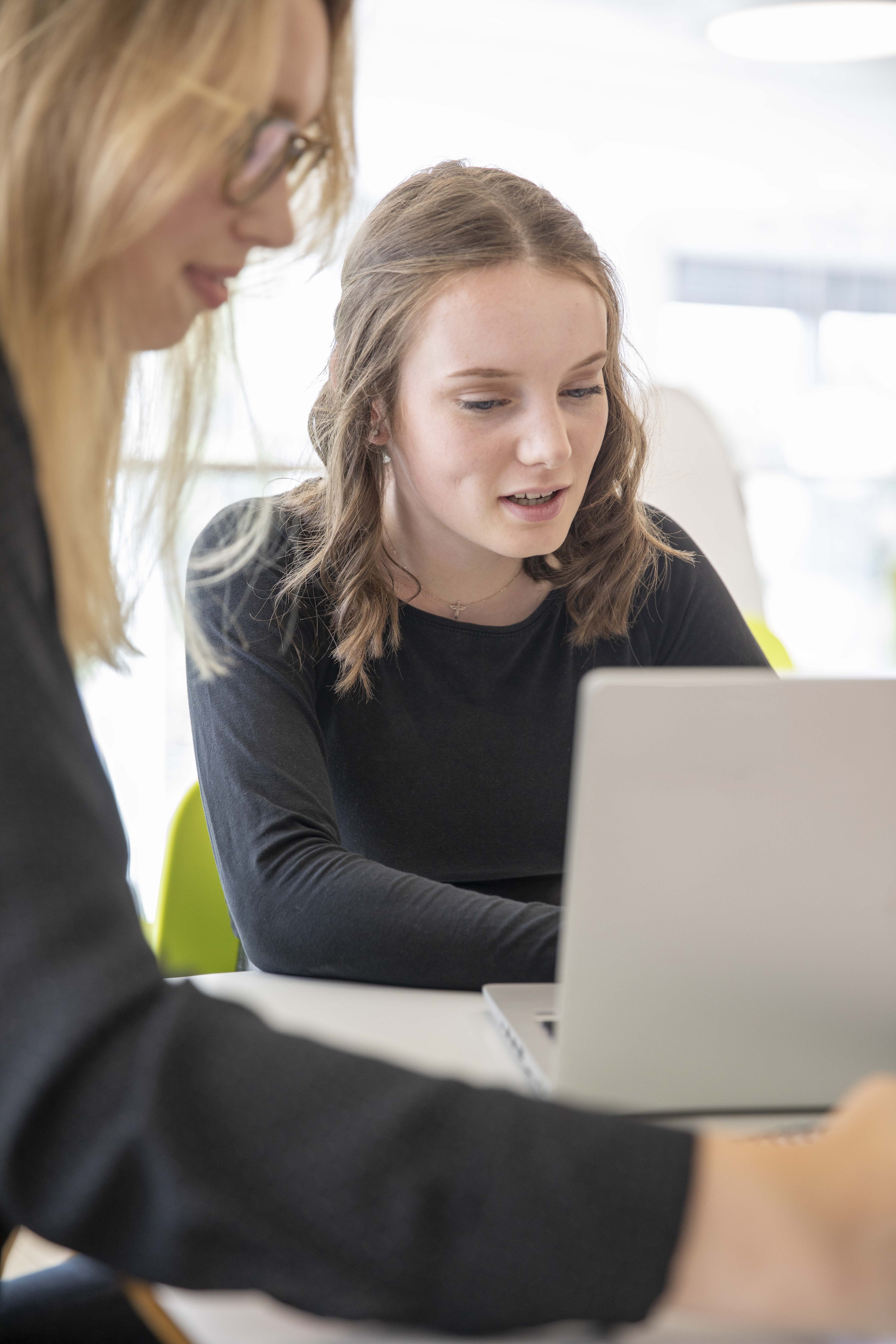 Deux employées travaillant ensemble sur leur ordinateur