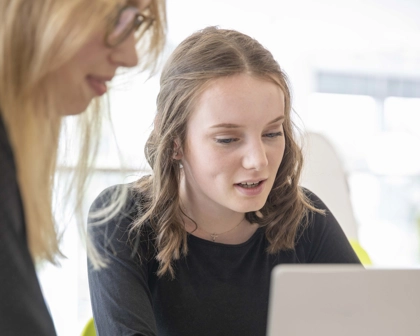 Deux employées travaillant ensemble sur leur ordinateur