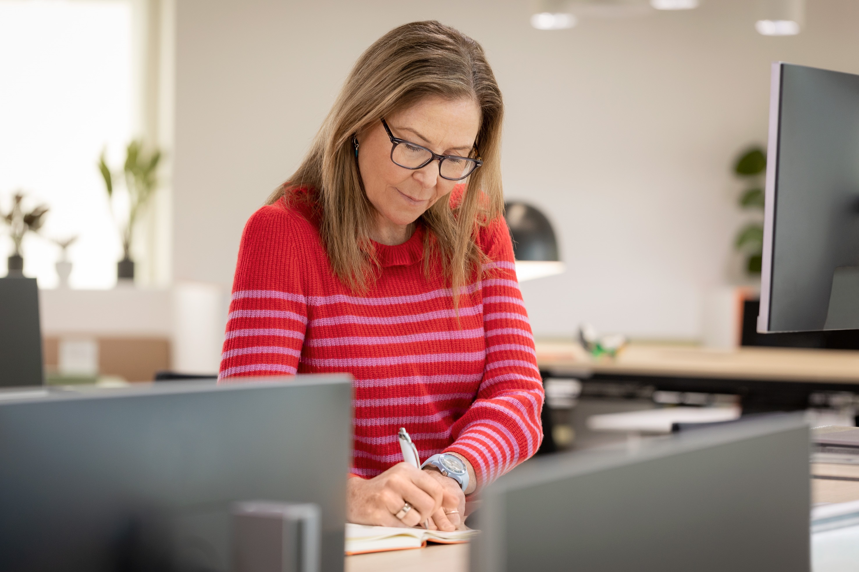 Employée qui travaille et écrit dans un bureau