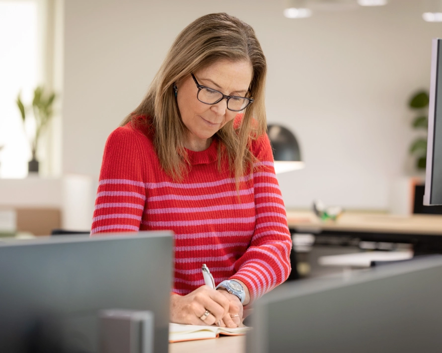 Employée qui travaille et écrit dans un bureau