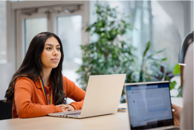 Femme devant son ordinateur regarde une autre personne