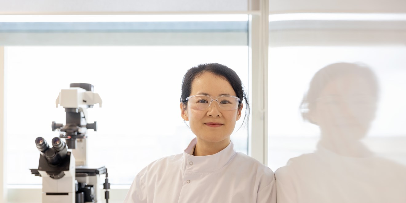 Femme scientifique dans un laboratoire avec lunettes et microscope