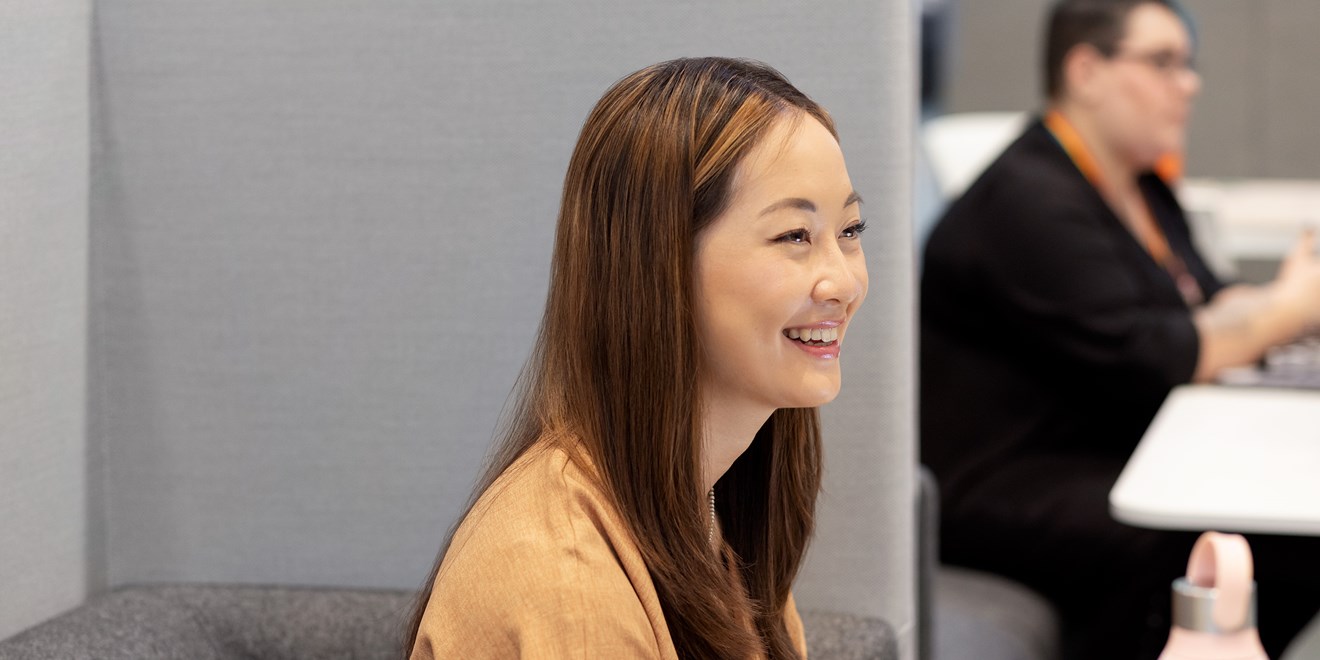 Employée assise à une table dans un bureau et souriant